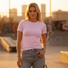 Female model in blossom pink Abstract Notion Tee with front “sixth.stitch.apparel” logo, warm golden hour lighting.
